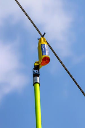 Electric voltage detector for 1kV to 69kV range, mounted on a utility pole, ensuring safety in electrical work.