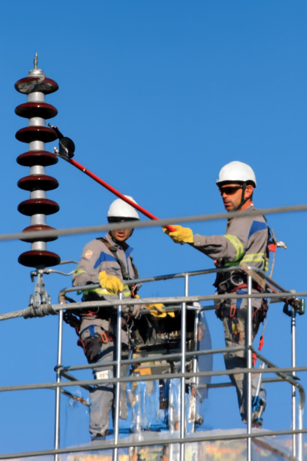 Technicians using a Live Line Insulator Tester IT500 on a utility pole to test ceramic and glass insulators.